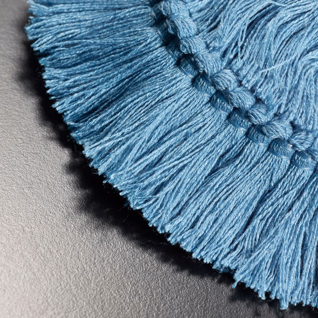 Close-up of cool turquoise-blue braided fringe with fine directional tassel texture
