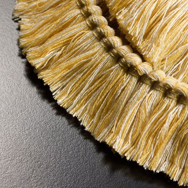 Antique-gold and cream fringed textile with raised braided edge detail