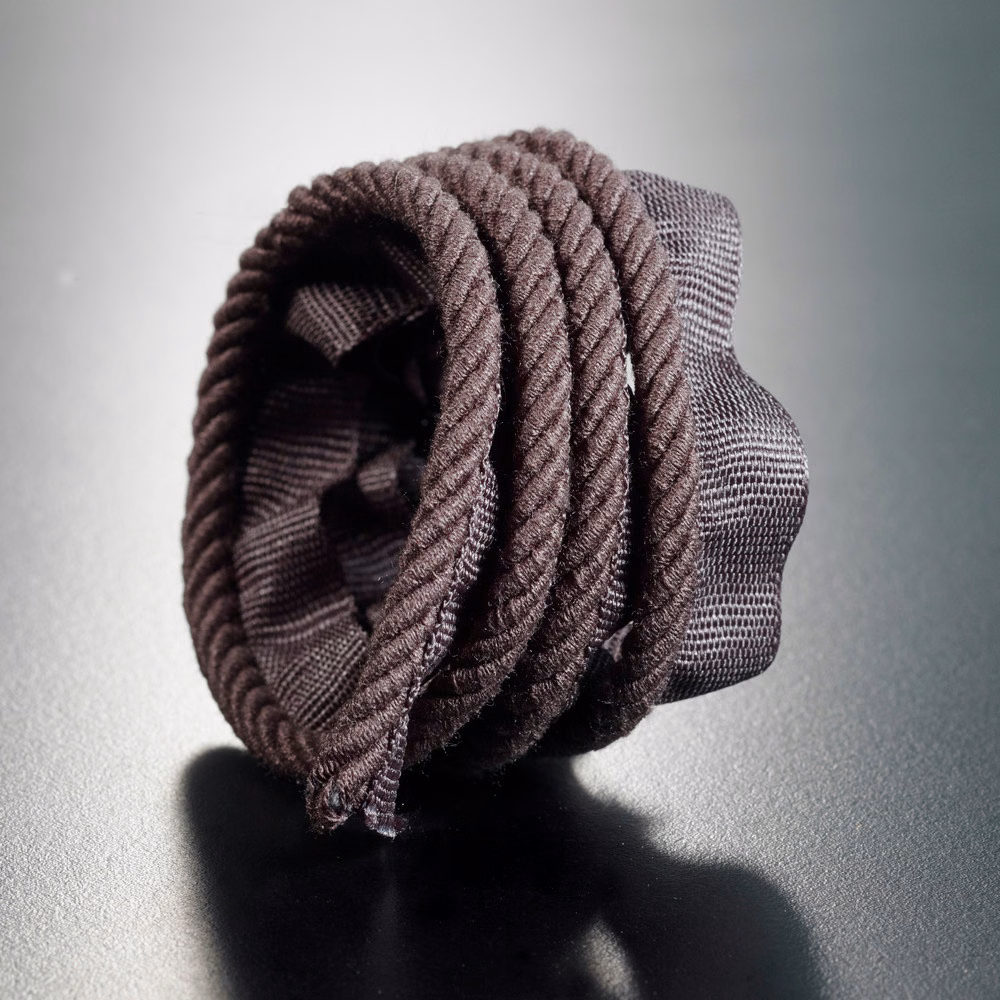 Near-black braided lipcord with raised ridges and subtle brown-grey highlights