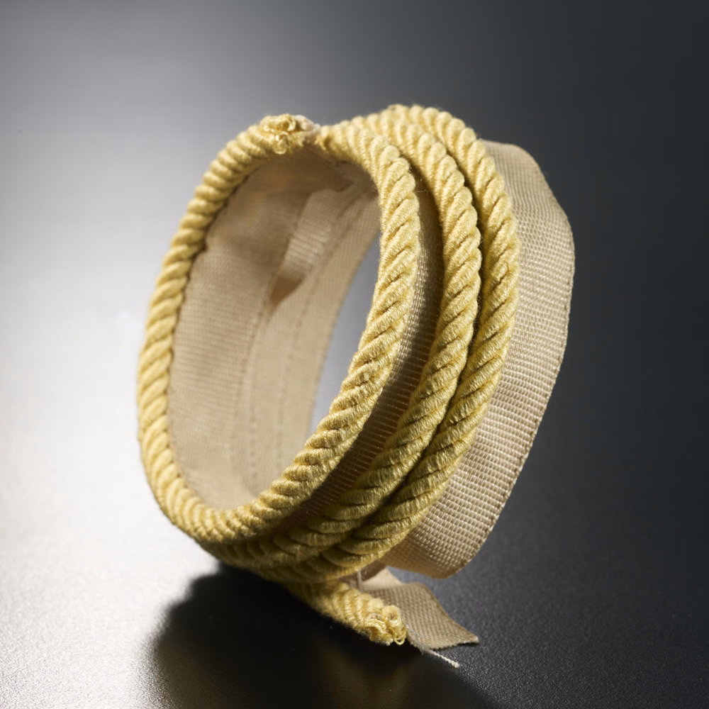 Soft straw-yellow braided lipcord loop with pale woven backing and pronounced ridged texture