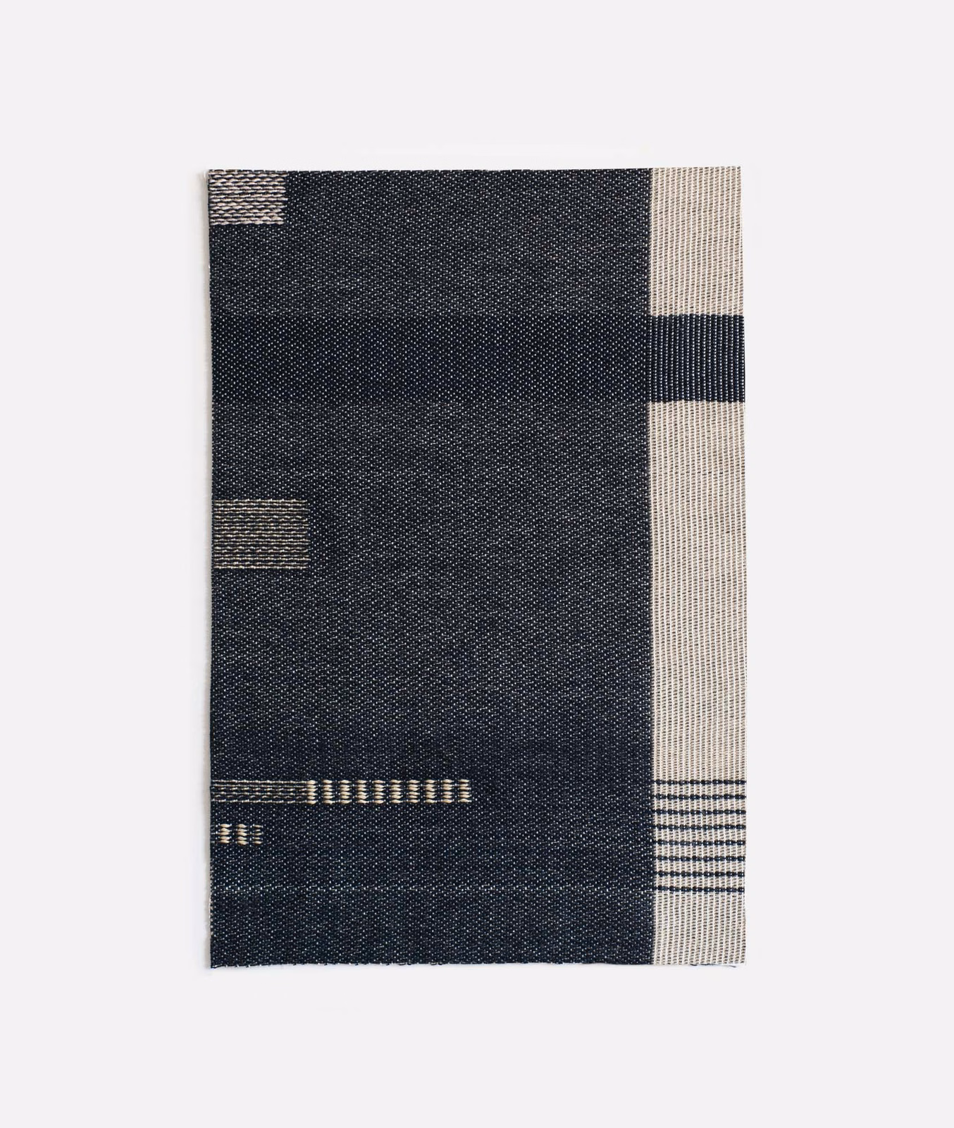 Charcoal-navy jacquard swatch with ivory blocks, slim bars and a finely woven surface
