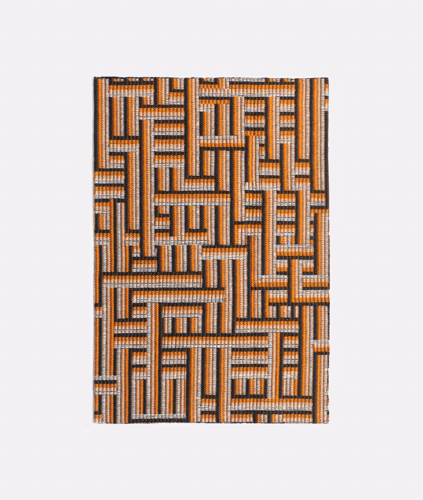 Warm terracotta, charcoal and ivory interlocking maze motif in textured jacquard weave