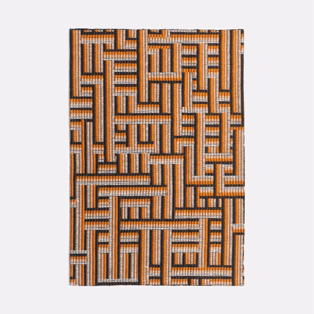 Warm terracotta, charcoal and ivory interlocking maze motif in textured jacquard weave