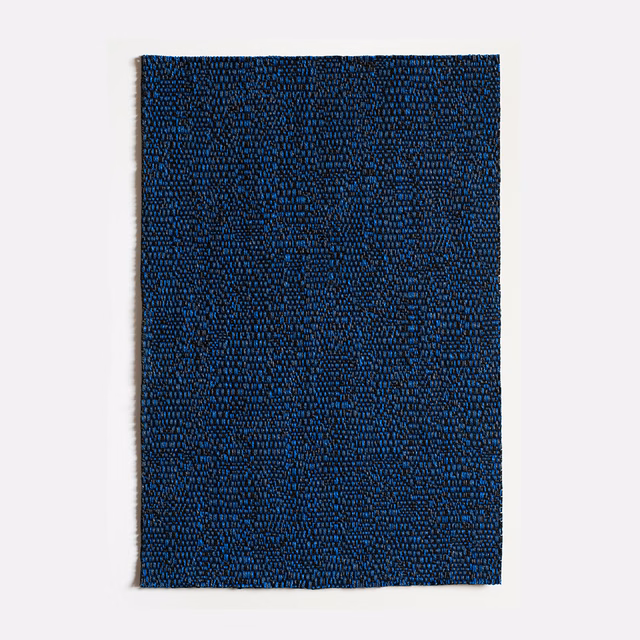 Deep ink-blue jacquard swatch with dense, tiny irregular marks and a tactile weave