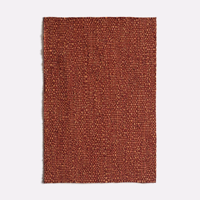 Warm paprika-red jacquard swatch with tiny irregular flecks and a nubby woven surface
