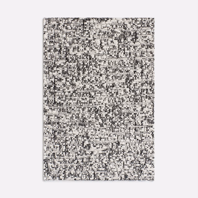 Off-white jacquard swatch with dense charcoal-black pixelated flecks and woven texture