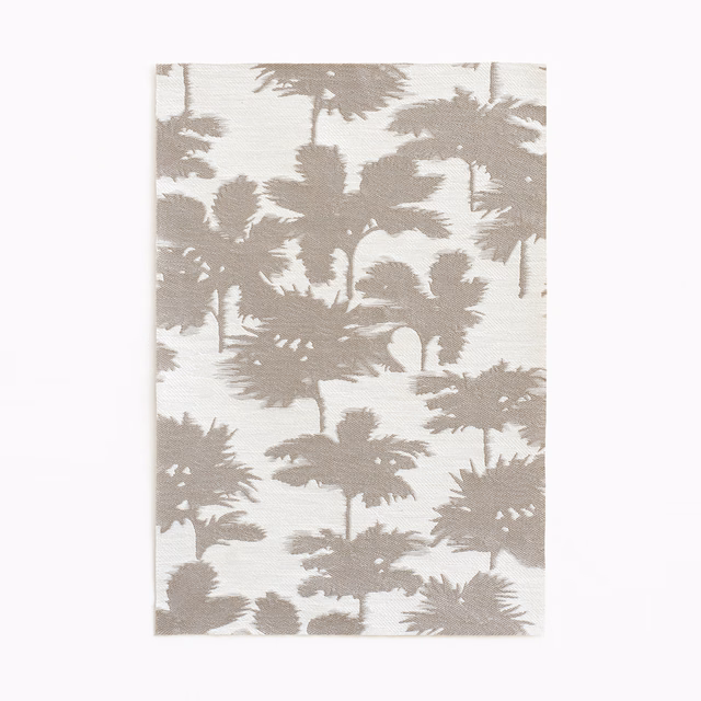 Warm taupe palm silhouettes across an ivory textured jacquard ground