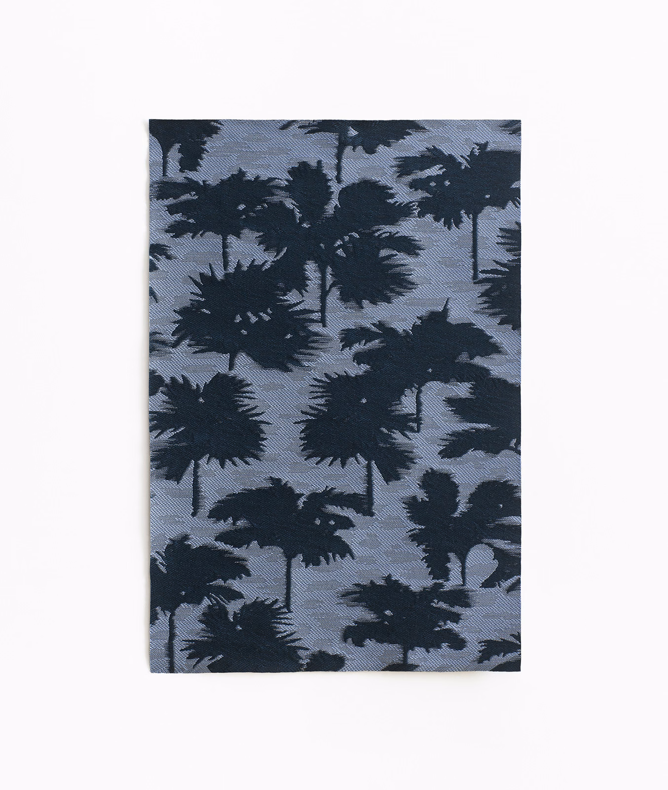 Slate blue jacquard with layered dark palm silhouettes and a subtly woven surface