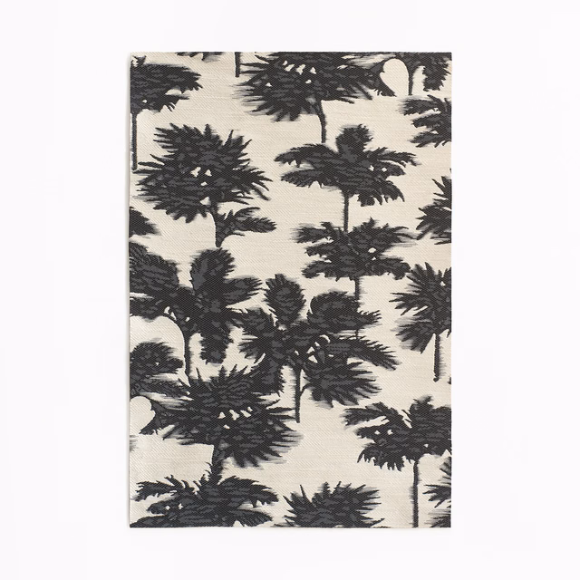Ivory jacquard swatch with dense charcoal palm silhouettes and textured woven foliage