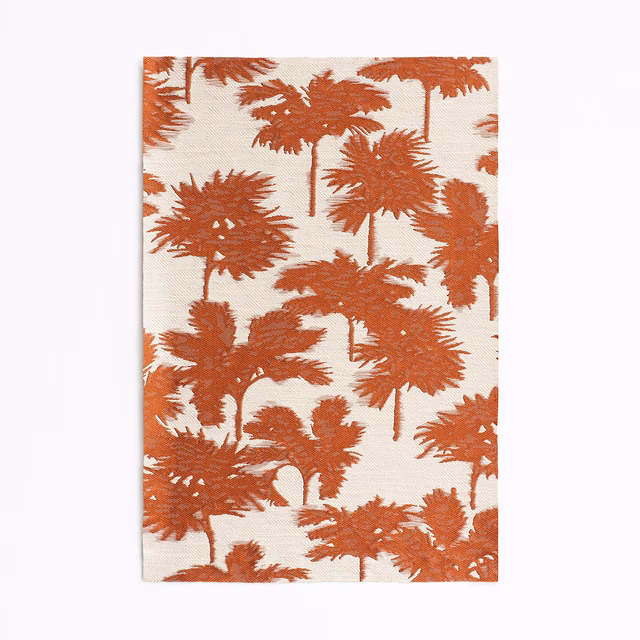 Terracotta palm silhouettes scattered across a warm ivory jacquard ground