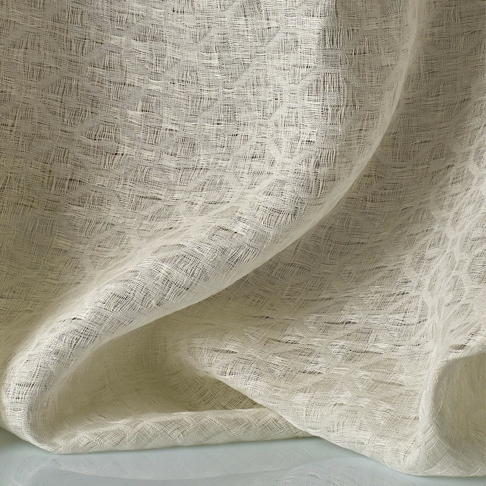 Warm ivory jacquard with airy crosshatched texture folding into soft translucent curves