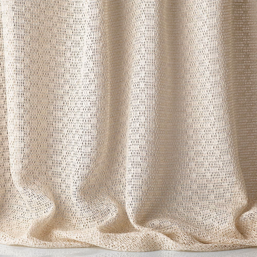Warm ivory jacquard with open geometric weave gathered into soft curtain folds