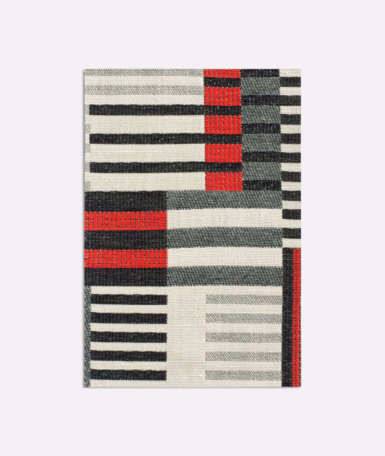 Geometric jacquard swatch with vivid red blocks, charcoal stripes and ivory ground