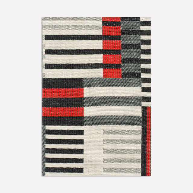 Geometric jacquard swatch with vivid red blocks, charcoal stripes and ivory ground