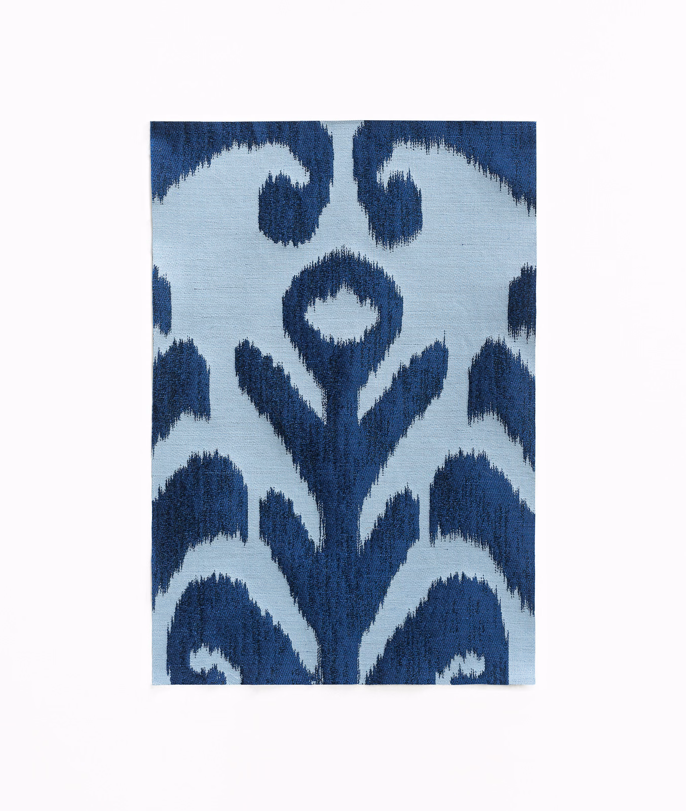 Icy pale-blue jacquard with deep navy ikat floral forms and feathery woven edges