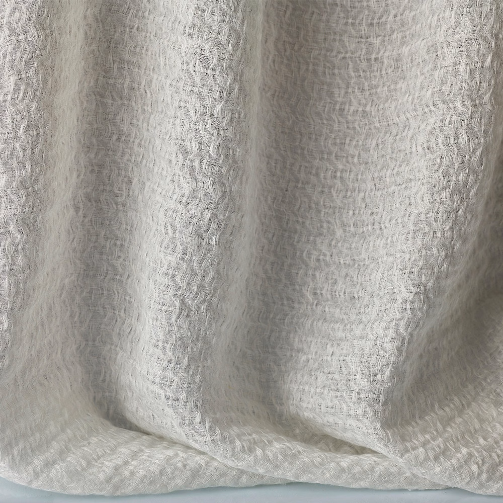 Soft warm-white jacquard with rippled woven texture falling in loose curtain folds