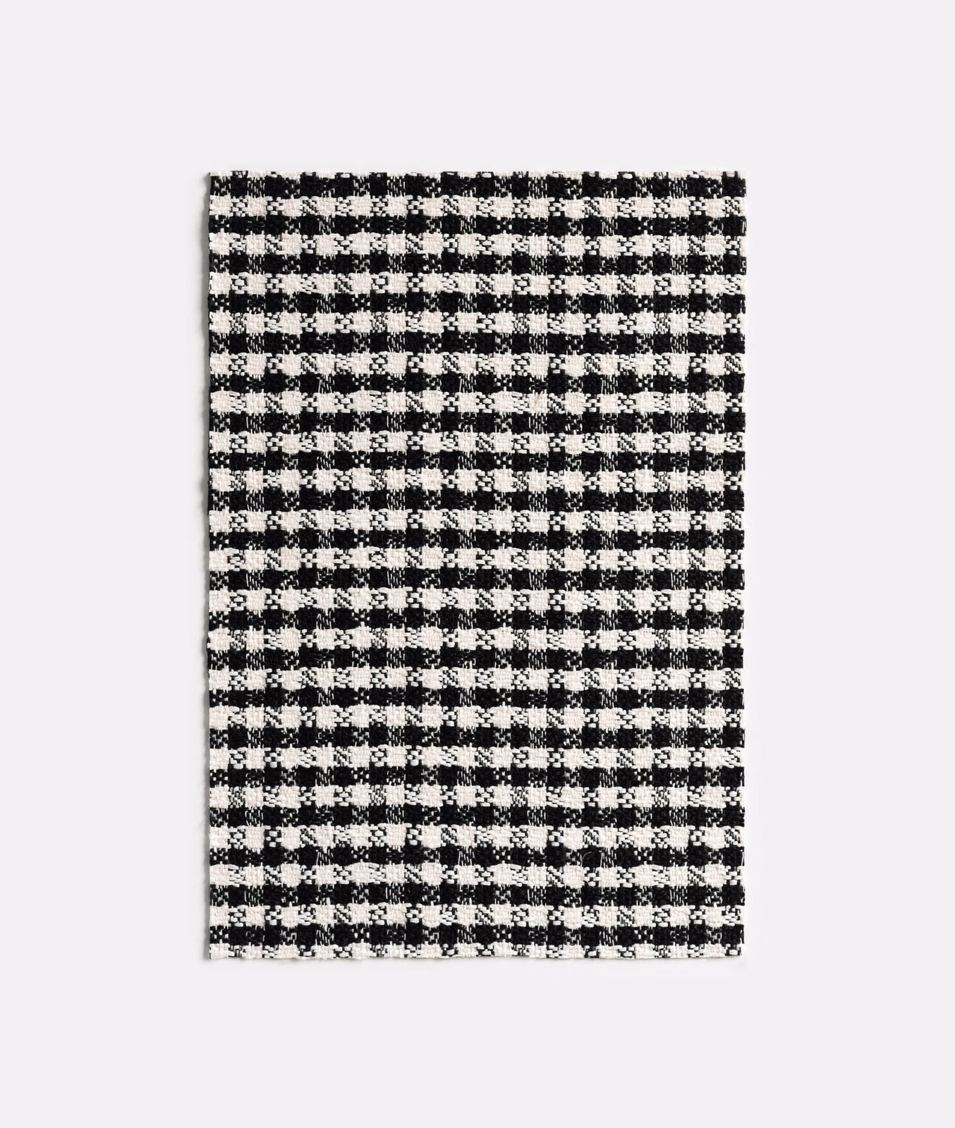 Close view of a small black-and-white checked jacquard weave with fuzzy texture