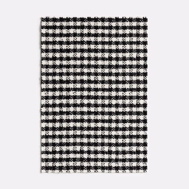 Close view of a small black-and-white checked jacquard weave with fuzzy texture