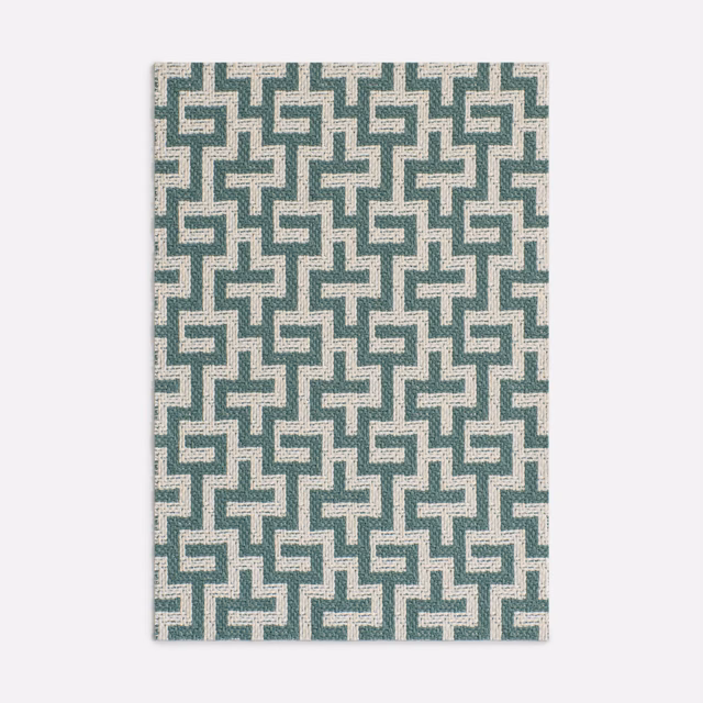 Muted lagoon-teal maze motif woven over a pale ivory ground