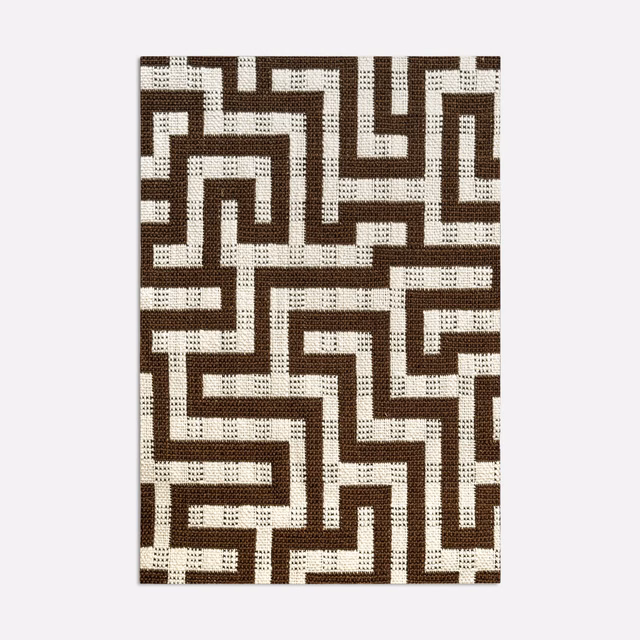Brown and cream jacquard swatch with interlocking maze lines and flecked woven texture