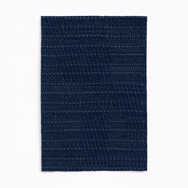 Deep marine-blue jacquard swatch with subtle patchwork bands and tactile woven texture