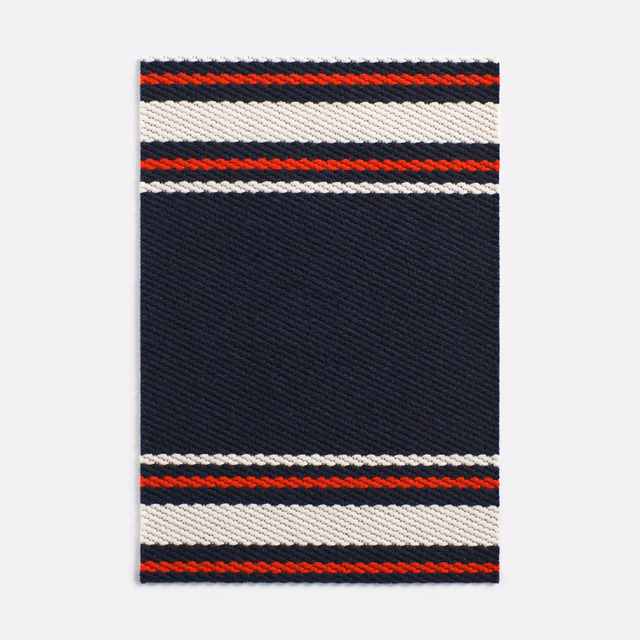 Deep navy twill with red, white and black horizontal woven bands