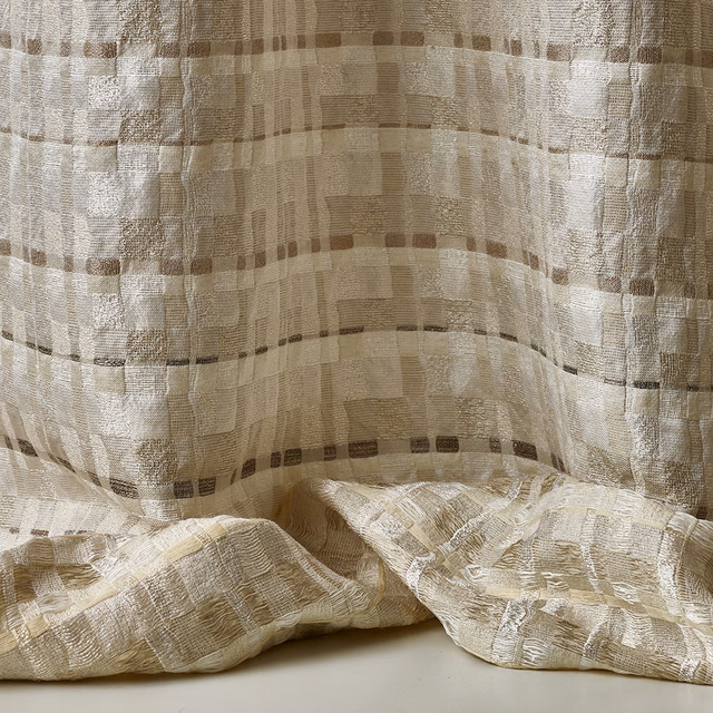 Warm ivory jacquard with taupe grid blocks and softly rippled folds