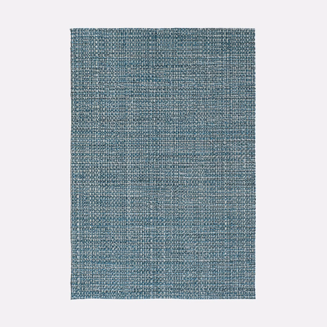 Close view of muted indigo-blue jacquard with a dense, crosshatched woven texture