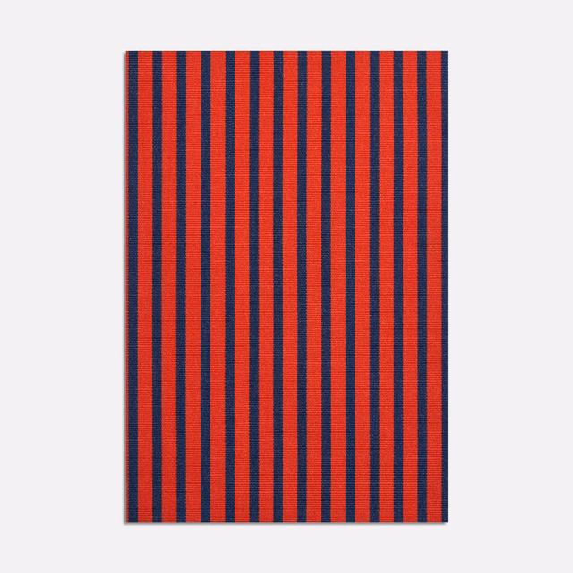Close view of narrow rouge and navy vertical stripes in a textured jacquard weave