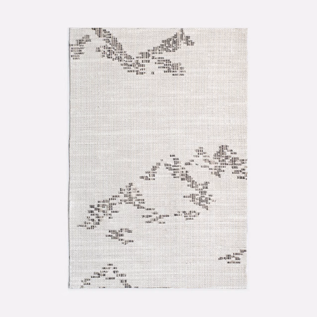 Pale grey jacquard with scattered charcoal pixel-like motifs and woven texture