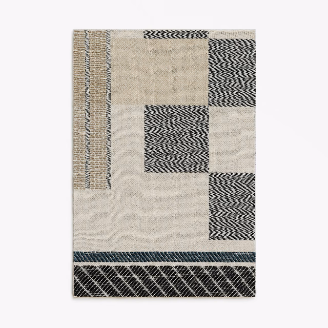 Black and silver zigzag blocks framed by ivory woven geometric panels