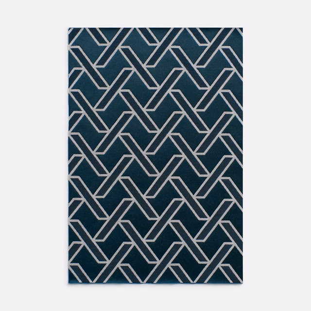 Deep blue-teal jacquard with pale interlocking angular lines in geometric repeat