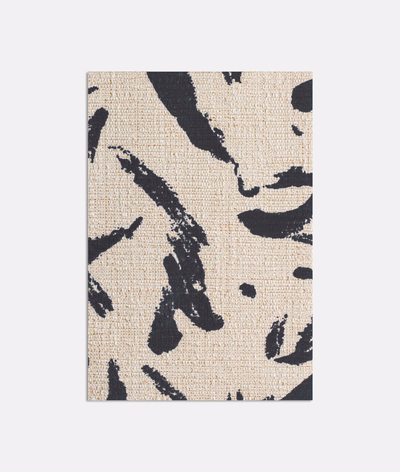 Warm beige woven fabric with bold black abstract brush strokes and scattered flecks