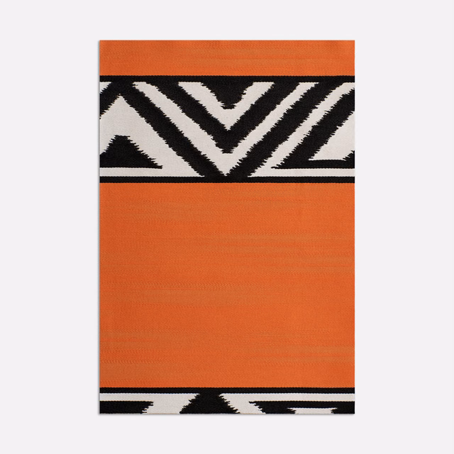 Burnt orange fabric with black and ivory chevron bands and fine woven texture