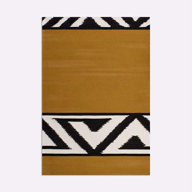 Warm ochre woven swatch with black-and-ivory angular geometric border bands