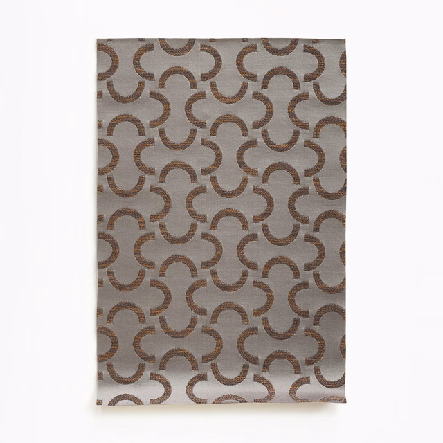 Taupe-grey satin weave with repeating brown interlocking crescent motifs