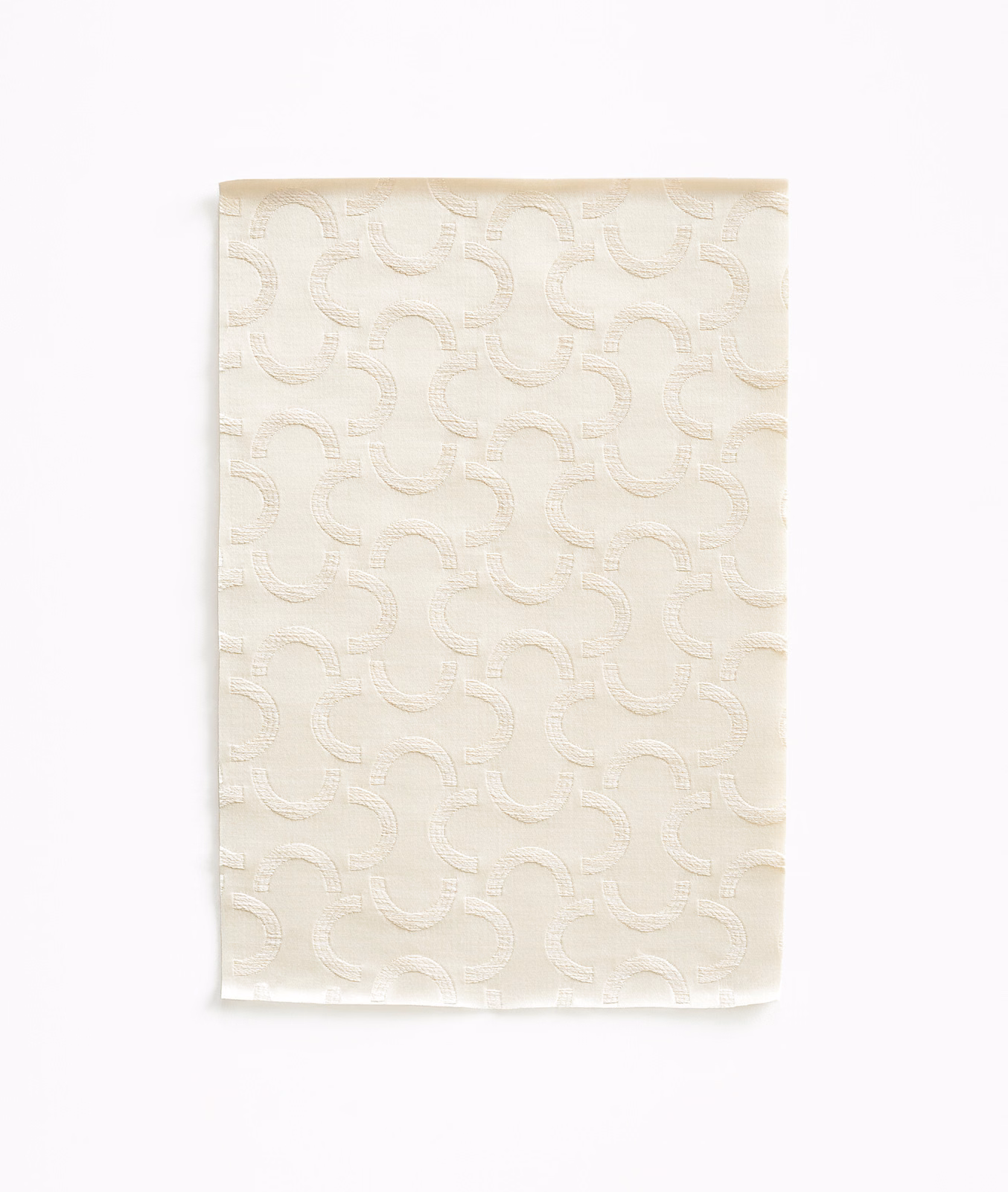 Warm ivory satin swatch with raised interlocking curved motifs and a gentle sheen