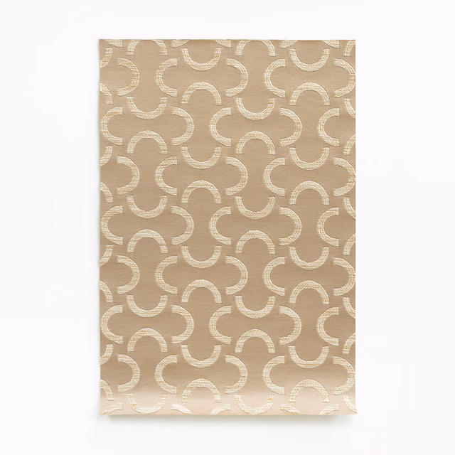 Warm beige satin swatch with repeating ivory curved arcs and subtle woven sheen