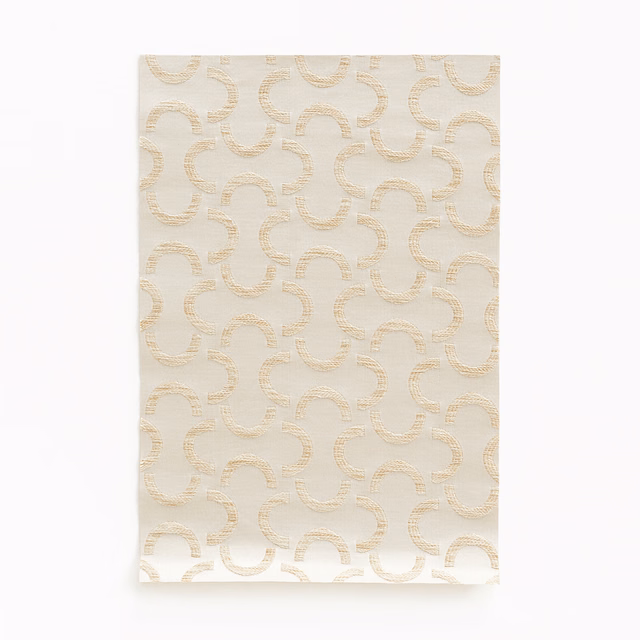 Warm ivory satin with pale champagne interlocking curves and subtle woven sheen
