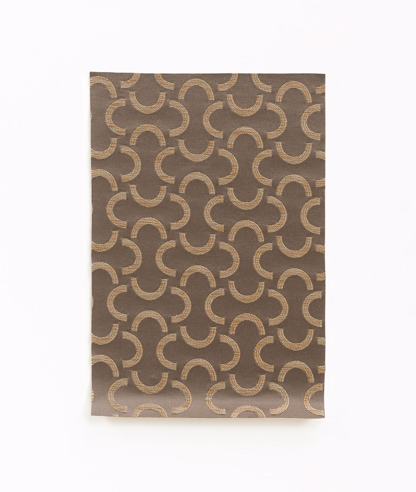 Warm taupe fabric with repeating beige-gold interlocking crescent motifs and a softly textured weave