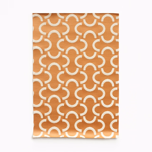 Warm melon-orange satin with repeating cream broken arcs and a subtle sheen