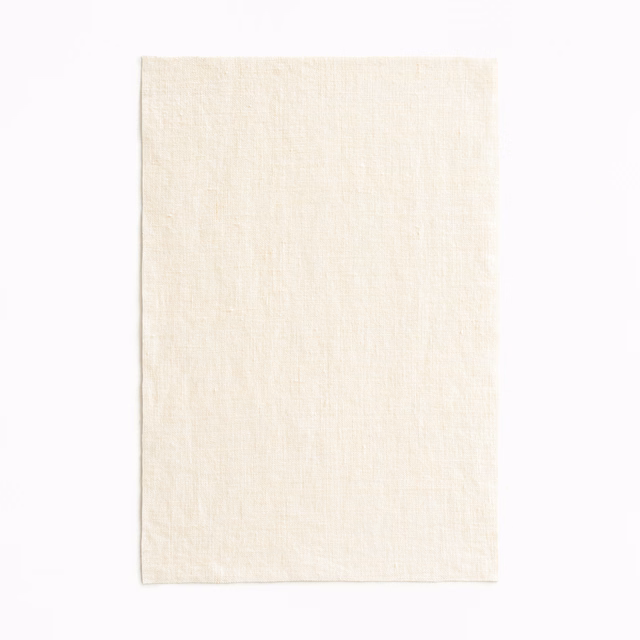 Warm ivory Adelphi Latte swatch with a fine, softly irregular woven texture