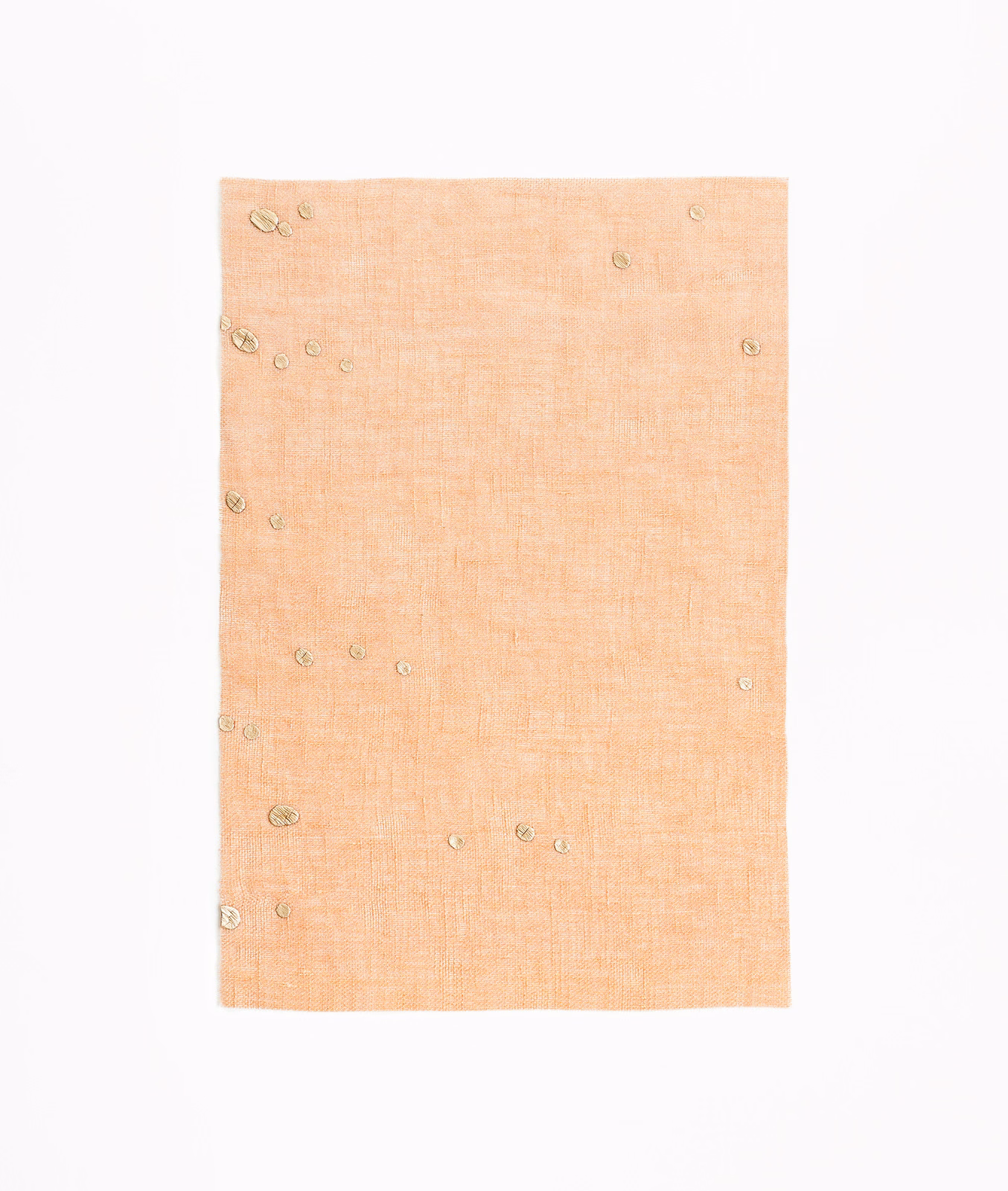 Pale peach sheer fabric with fine crosshatch texture and scattered circular confetti