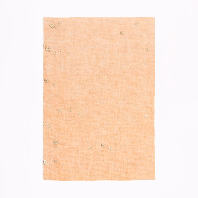 Pale peach sheer fabric with fine crosshatch texture and scattered circular confetti