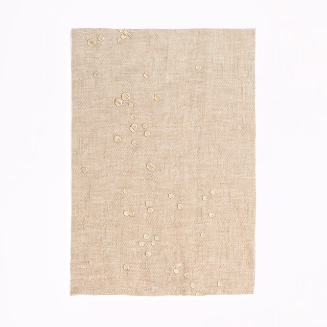 Sand-beige sheer ground with scattered raised circular confetti details and fine crossweave
