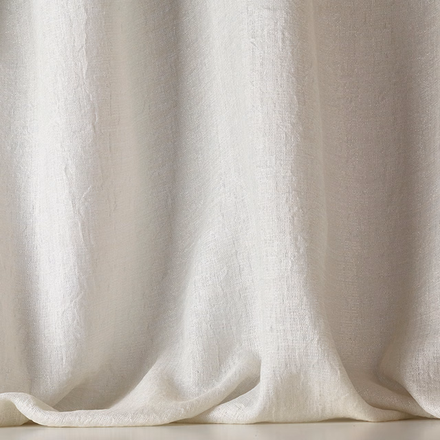 Soft ivory sheer with irregular vertical slubs, falling in luminous, fluid folds