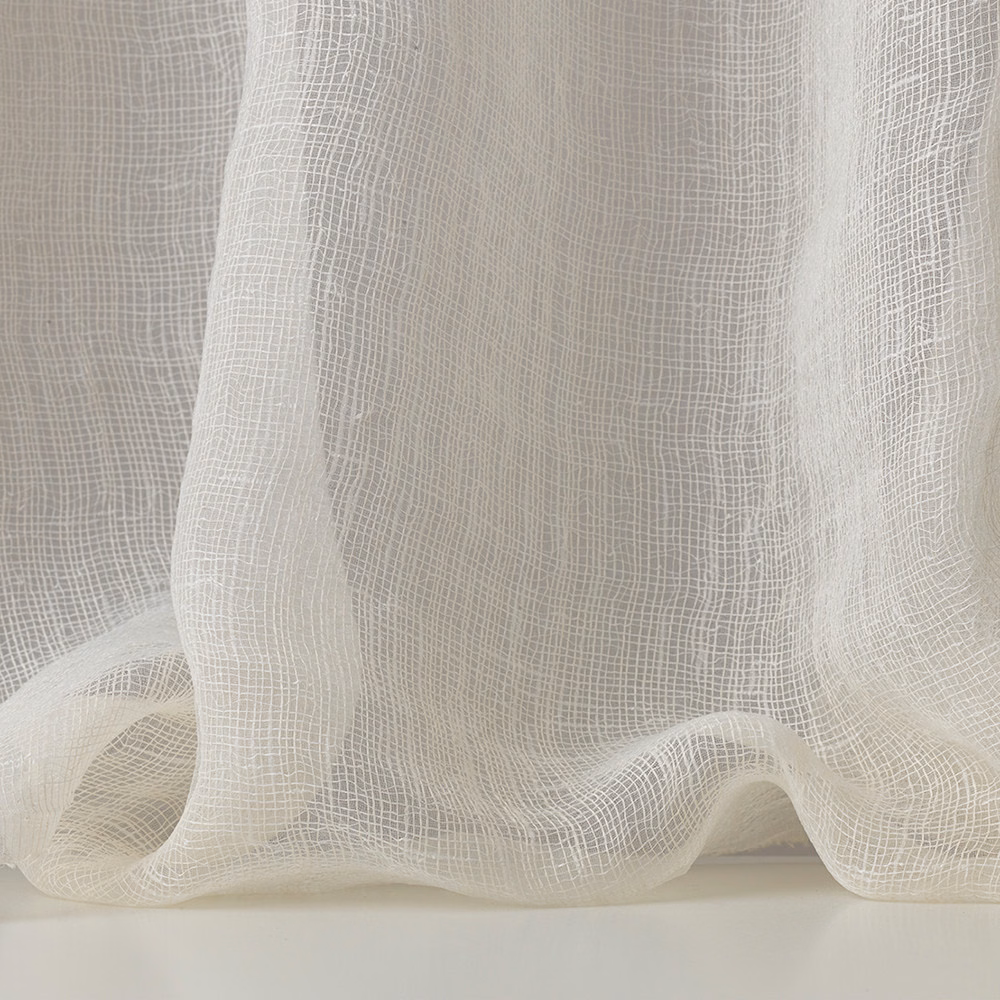 Warm ivory open-grid gauze falling in translucent, softly gathered folds