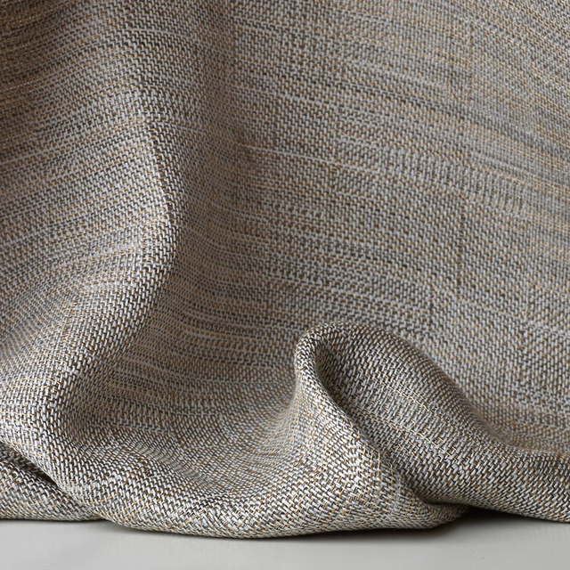 Muted greige-gold sheer fabric with fine herringbone weave in soft draped folds