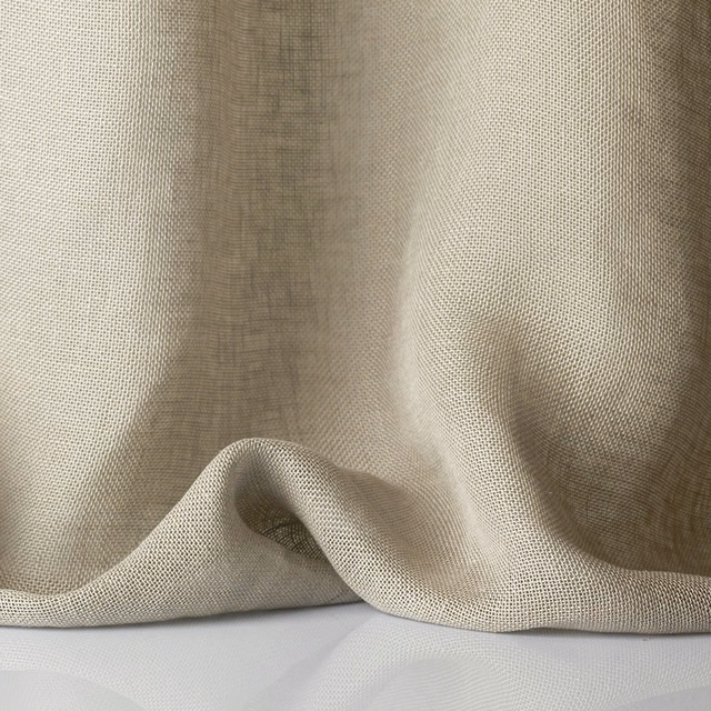 Pale stone greige sheer fabric with open weave falling into softly shadowed folds