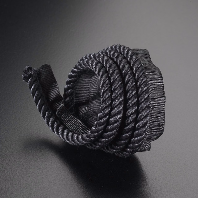 Charcoal-black braided lipcord with silver-grey highlights and pronounced ridged texture